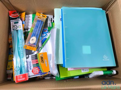 une boîte remplie de fournitures scolaires, de stylos et de crayons