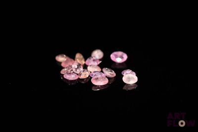 some pink and white diamonds on a black surface