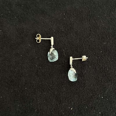 pair of earrings with blue topaz stone on black background