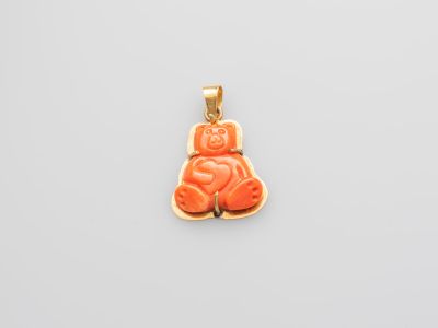 un pendentif en forme d'ours aux couleurs or et corail sur fond blanc