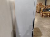 a white refrigerator sitting in a warehouse next to a pallet