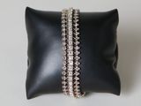 un oreiller noir sur lequel sont posés deux bracelets
