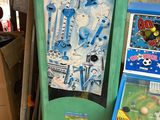 a green and yellow vending machine next to a box of candy