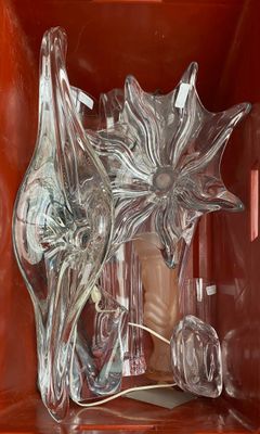 un vase en verre contenant une fleur, posé sur une étagère