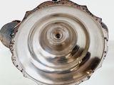 a silver vase with a handle on a white table