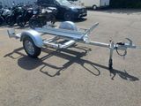 a trailer with a motorbike attached to it in a parking lot