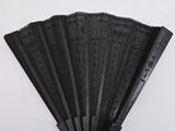 a black fan hanging on the wall next to a white wall
