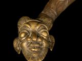 a close up of a wooden stick with a face on it