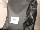 a black bag sitting on the grass next to a bike