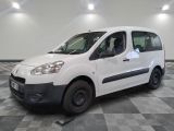 La petite camionnette blanche est garée dans une grande pièce.