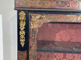 a black and gold cabinet with a mirror on top of it