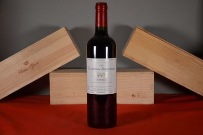 a bottle of wine sitting on a table next to two wooden boxes