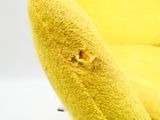 une chaise jaune qui a un trou dans le dossier