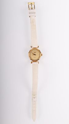 un gros plan d'une montre sur une surface blanche avec un fond blanc