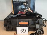 une boîte contenant un appareil photo et quelques autres objets, posée sur une table