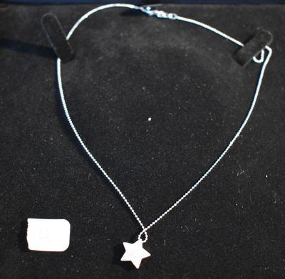 un collier en argent orné d'un pendentif en forme d'étoile sur fond noir