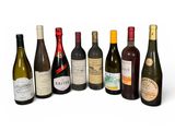 plusieurs bouteilles de vin sont alignées sur une surface blanche