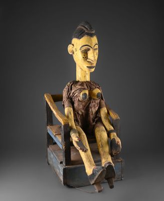 une image représentant une sculpture en bois d'un homme assis sur une chaise