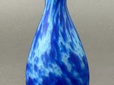a blue and white vase sitting on a gray surface