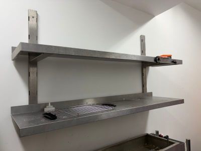 une cuisine équipée d'un évier et d'une étagère