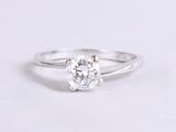 a close up of a diamond ring on a white surface