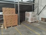 boxes and pallets in a storage room with a ladder