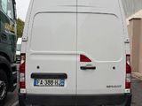 a white van parked in a parking lot next to a green truck