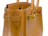 the brown leather handbag has two handles and a gold handle