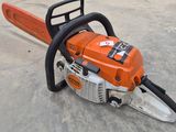 an orange and black chainsaw sitting on top of a cement floor