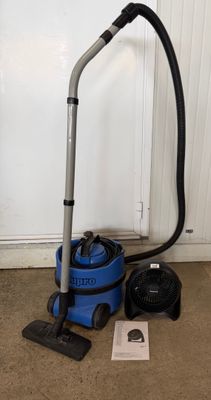 a blue vacuum cleaner sitting on top of a carpet next to a black vacuum