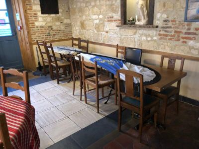 tables and chairs in a restaurant with a brick wall and a blue door