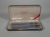 a silver case with a pair of scissors inside of it