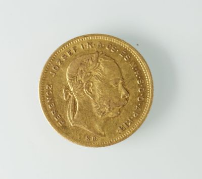 gros plan d'une pièce d'or sur une surface blanche
