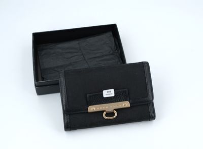 black leather wallet with a gold buckle in a black box