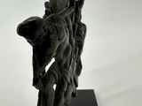 statue of a man on a tree branch with a bird perched on it
