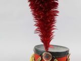 a close up of a red and black hat with feathers on it