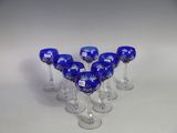 six wine glasses are lined up in a row on a white surface