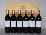 six bouteilles de vin rouge sont alignées devant une caisse en bois