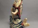 figurine en céramique représentant un poisson coiffé d'une couronne