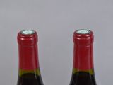 two bottles of wine sitting on top of a table next to each other