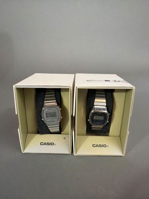 une paire de montres Casio dans un coffret posé sur une surface grise