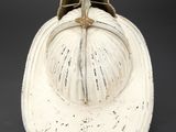 an old white fireman ' s hat with a brass buckle