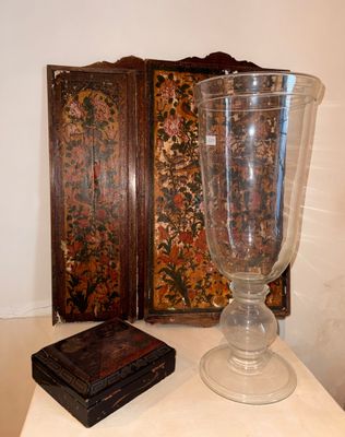 un grand vase en verre posé sur une table, à côté d'une petite boîte en bois