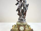 une statue représentant un garçon et une fille sur une horloge