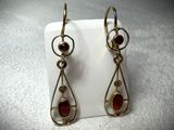 pair of gold tone earrings with garnets and garnets on them
