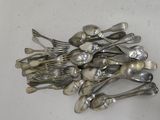 a pile of silver spoons and forks on a table