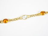 gros plan d'un bracelet en or avec des pierres multicolores