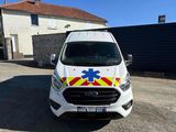the white van is parked in front of a building with an ambulance on it ' s side