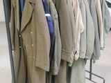 a lot of coats hanging on a rack in a room