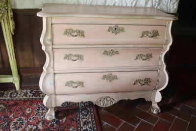 a dresser with a bed and a rug on the floor